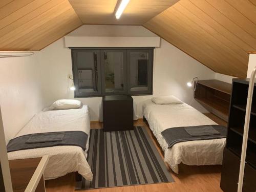 Una habitación con dos camas y una ventana. en Late, Duplex house apartment for 7 near Meyer gate, en Turku