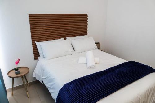 a bedroom with a white bed with a wooden headboard at Bonnie house in Crocodile Valley Estates