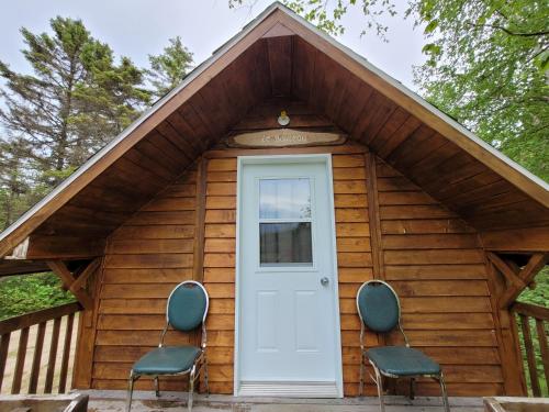 a small cabin with two chairs in front of it at Centre de Vacances 5 Étoiles Family Resort in Sacré-Coeur-Saguenay