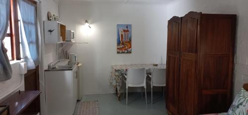 eine kleine Küche mit einem Tisch mit Stühlen und einem Kühlschrank in der Unterkunft 19 on Robyn in Durbanville