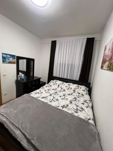 a small bedroom with a bed and a mirror at Feti’s cozy apartment near the park city in Pristina