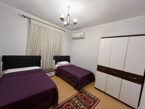 1 Schlafzimmer mit 2 Betten und einer Kommode in der Unterkunft Chelay Apartments in Kairo