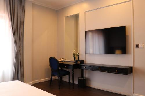 a hotel room with a desk and a television at Indigen Boutique Hotel Cao Bang in Cao Bằng