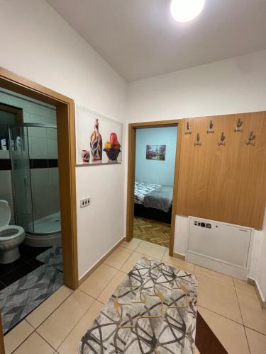 a bathroom with a shower and a toilet and a bed at Feti’s cozy apartment near the park city in Pristina