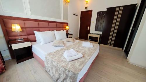 een slaapkamer met een groot bed en 2 handdoeken bij Steaua Apelor Family Resort in Nufăru