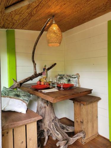 une table en bois dans une pièce avec une souche d'arbre dans l'établissement La case, à Thuir