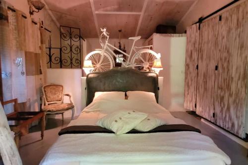 - une chambre avec un grand lit et un vélo sur le mur dans l'établissement La case, à Thuir