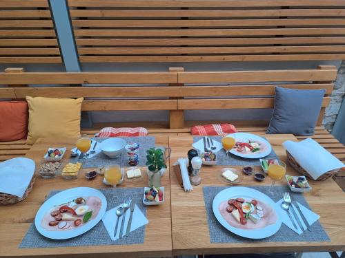 a wooden table with plates of food on it at Ubytovanie u Janusa in Levoča