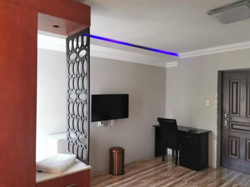 a room with a room with a desk and a tv at Zurich Garden Hotel in Benoni
