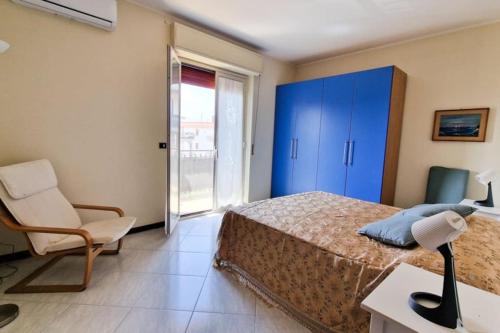 a bedroom with a bed and a blue cabinet and a chair at Home Sicilian Gallery in Aci Castello