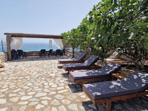 - une rangée de chaises longues sur une terrasse donnant sur l'océan dans l'établissement Ktima Zaxarias, à Kokkala