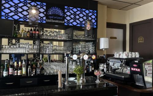 a bar with a lot of bottles of alcohol at Hôtel OpalOriental in Boulogne-sur-Mer