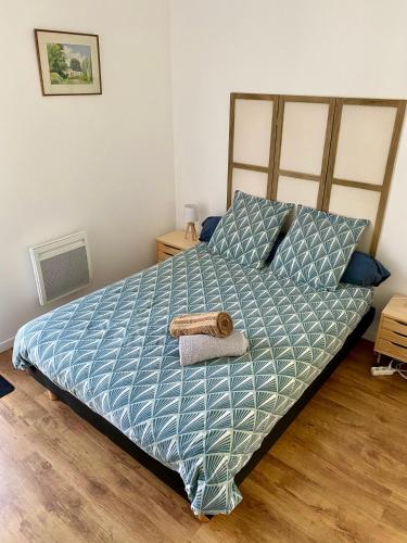 a bedroom with a bed with a blue comforter at Chambre indépendante et paisible dans maison neuve in Mimizan