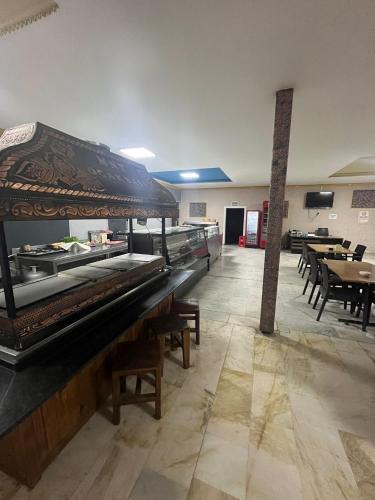 a large piano in a room with tables and chairs at Kılıç AirPort otel in Seydiköy