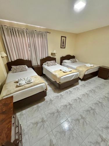 two beds in a hotel room with at Hotel Madrid Chiriqui in David