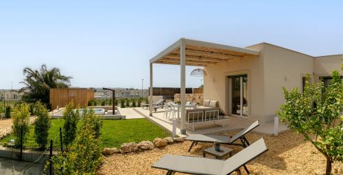 a patio with a table and chairs in a yard at Scacciapensieri Sea House in Brucoli