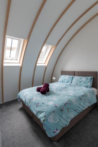 a bed with a blue comforter in a bedroom at King's Head Cottage in Hastings