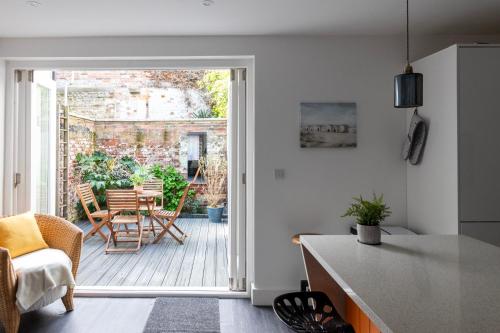 a kitchen and living room with an open door to a patio at King's Head Cottage in Hastings