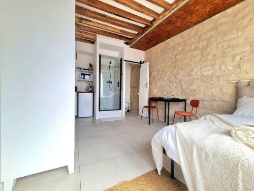 une chambre avec un lit et une table avec des chaises dans l'établissement Studio de charme, à Fontenay-aux-Roses