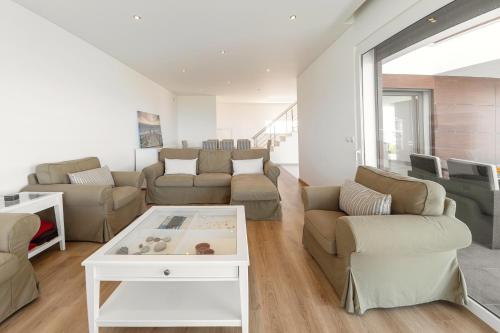 a living room with a couch and a table at Poolside & Seaview Villa in Lourinhã