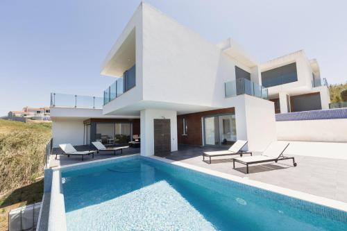 a villa with a swimming pool and a house at Poolside & Seaview Villa in Lourinhã