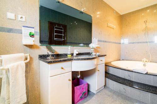 een badkamer met een wastafel, een bad en een spiegel bij Casa Monte Beira Rio in Touguinho