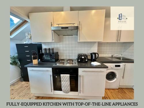 a kitchen with white cabinets and a stove top oven at The Chambers Presents Long stay Offers in Leeds