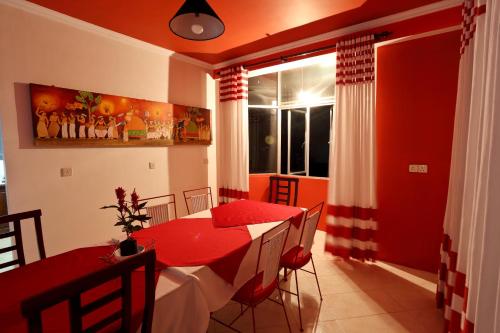 a red dining room with a red table and chairs at RedHill Kandy in Kandy