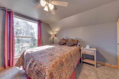 a bedroom with a bed and a window at Tall Pines Treehouse with Deck and Hot Tub! in Ruidoso