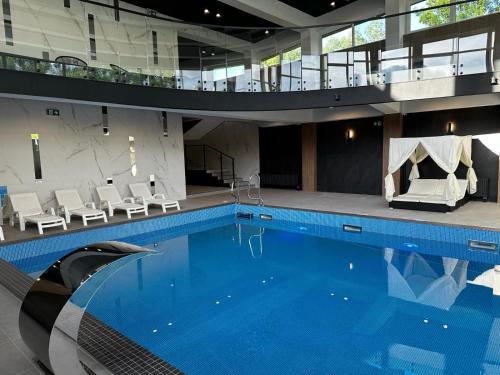 a large swimming pool in a building with chairs at WRZOS resort & wellness **** DOMKI CAŁOROCZNE in Węgierska Górka