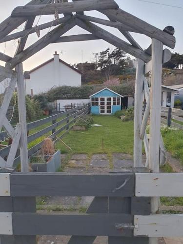 a wooden pergola in a yard with a house at Seabird at Trearddur Bay in Trearddur