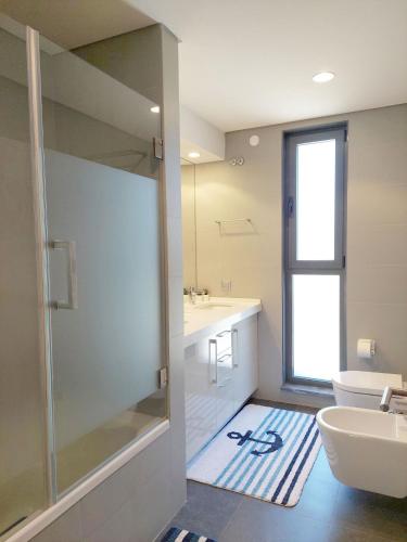 a bathroom with a shower and a sink and a toilet at Quartos com casa de banho privada perto da Malveira in Asseiceira Grande
