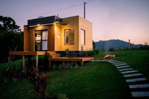 a small house sitting on top of a lush green field at Cabanas Sunset View in Urubici
