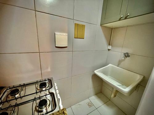 a small kitchen with a stove and a sink at Apartamento Luxo com Piscina em Ponta Verde in Maceió