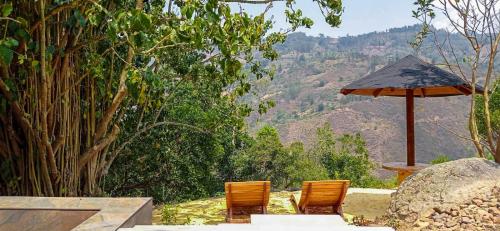 a patio with two chairs and an umbrella at Glamping Corazón del Molino in Ubaque