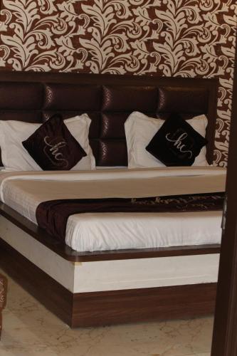 a bed with black and white pillows on it at HOTEL HOLY CITY in Amritsar