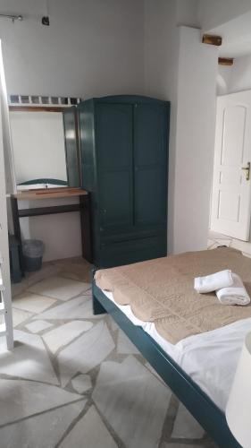 a bedroom with a bed and a green cabinet at Stone Oasis apartment Vari Syros in Vari