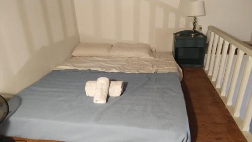 a bed with two folded towels on it in a room at Stone Oasis apartment Vari Syros in Vari