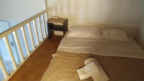 a bed sitting in a room with a stair case at Stone Oasis apartment Vari Syros in Vari