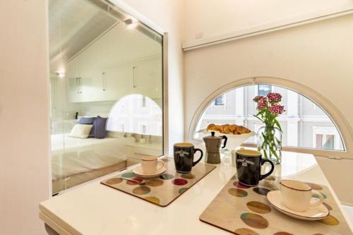 a room with a table with two mugs and a mirror at Attico New Bussola Cagliari in Cagliari