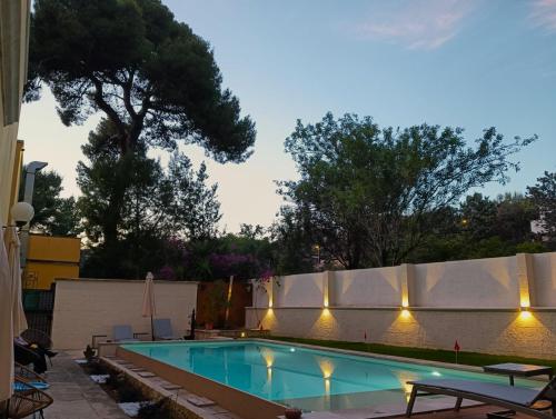 una piscina en un patio trasero con luces en una valla en Dimora Relais Excelsa, en Gallipoli