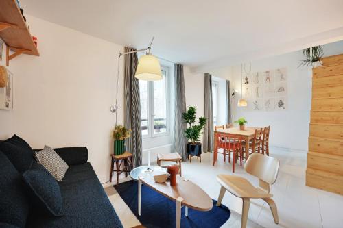 un salon avec un canapé et une table dans l'établissement Appartement charmant avec vue - Montmartre, à Paris