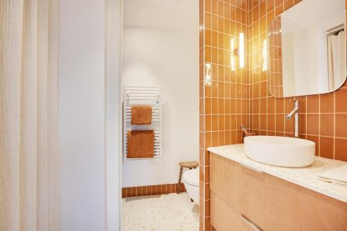 une salle de bain avec un lavabo et des toilettes dans l'établissement Appartement charmant avec vue - Montmartre, à Paris