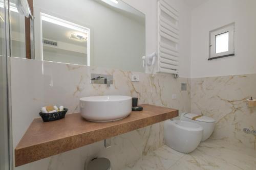 a white bathroom with a sink and a toilet at Donna Adriana Rooms in Agropoli