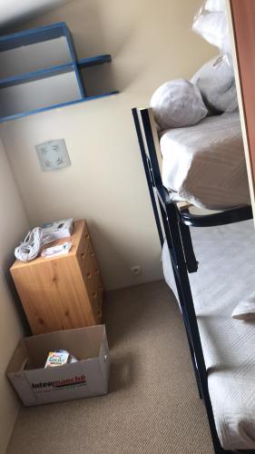une chambre avec deux lits superposés et un coffre au sol dans l'établissement Mobil Home, à Siouville