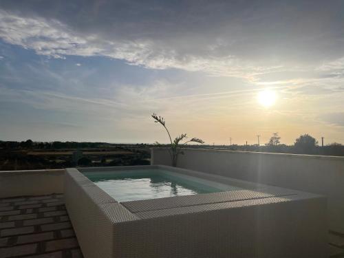 a swimming pool on the roof of a house at Masseria Vico in Villaggio Resta