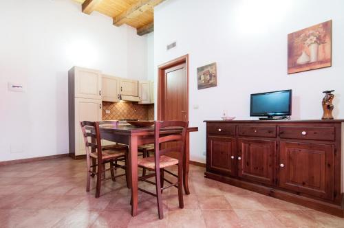 a kitchen with a table and chairs and a television at Le Case Al Quadrato in Siracusa
