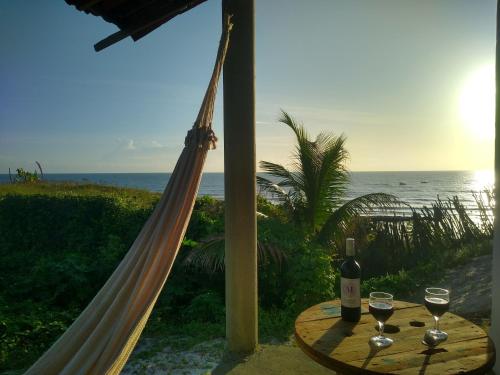 阿拉卡蒂的住宿－Casinha Estrela do Mar o Oceano aos seus Pés，一张桌子,上面有两杯葡萄酒在沙滩上