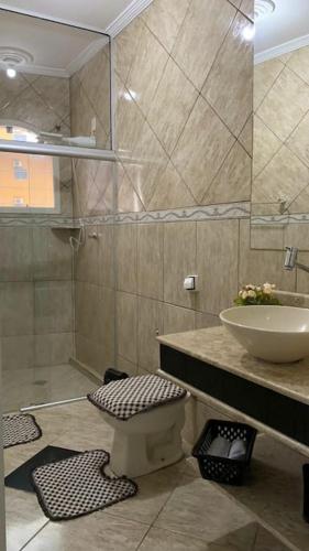 a bathroom with a sink and a shower and a toilet at Casa de Maria in Aparecida
