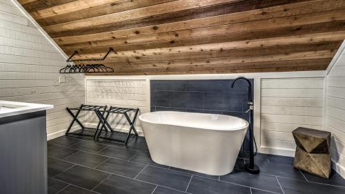 a bathroom with a white tub and a wooden ceiling at Sunrise and Stardust in Mashburn Mill